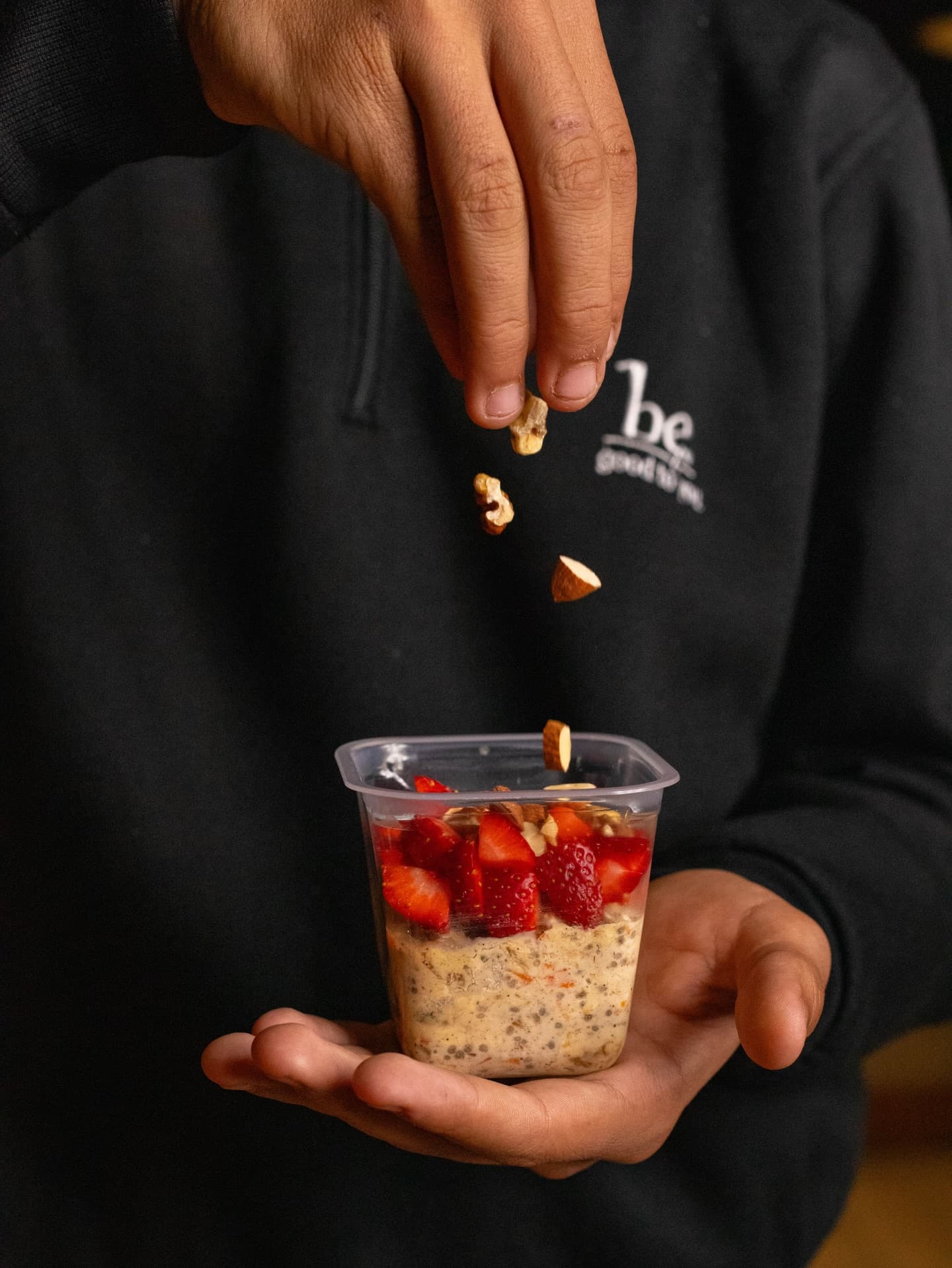 Preparing overnight oats with fresh strawberries and nuts